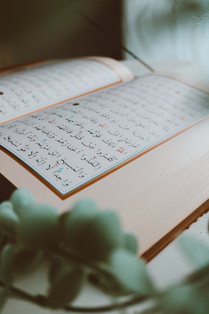 programs-03 An open Quran on a table with floral decor, providing a serene and spiritual atmosphere.