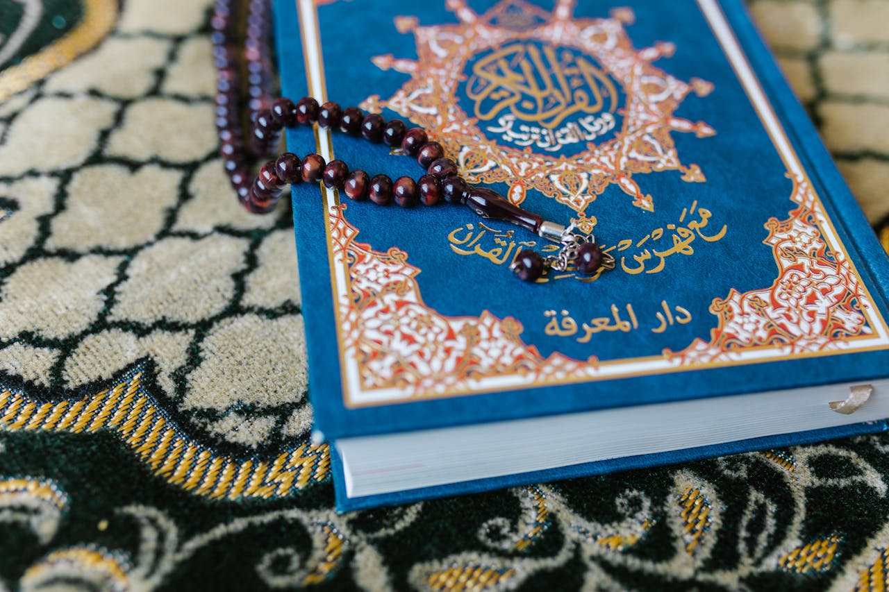 hero-gallery-03 A Quran with prayer beads on a decorative carpet, symbolizing Islamic spirituality.