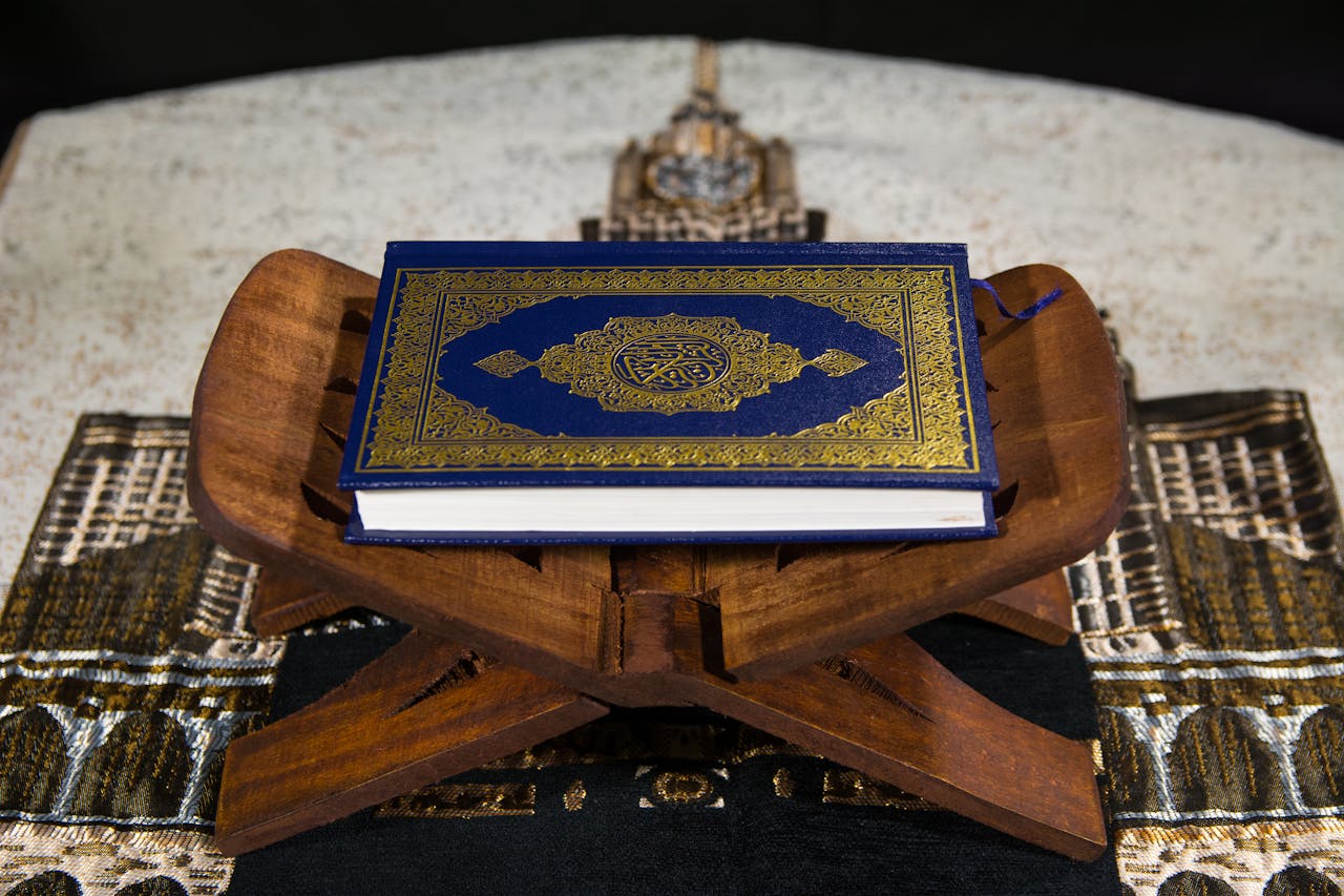 gallery-img-01 Close-up of the Quran on a wooden stand, symbolizing Islamic spirituality.